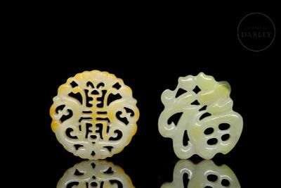 Pair of carved jade pendants, 20th century. Two carved jade pendants, white-green in colour with 