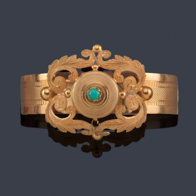 : Pulsera r&iacute;gida con motivos vegetales y turquesa central en cabuj&oacute;n, realizada en oro amarillo 