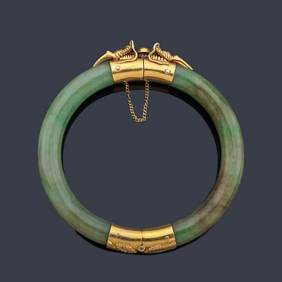 : Pulsera r&iacute;gida realizada en jade con dos motivos de cabeza de drag&oacute;n en oro amarillo de 18K. 