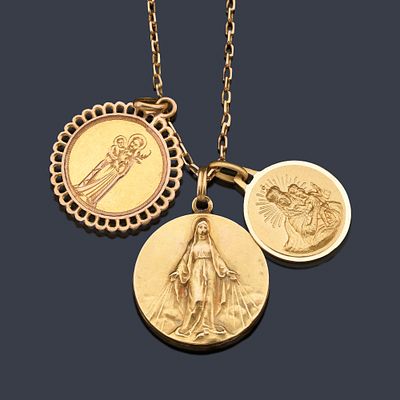 : Lote compuesto de tres medallas religiosas y cadena de eslab&oacute;n fino de oro amarillo de 18K. Lo 