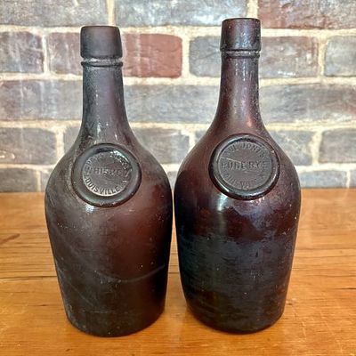 A Pair of Paul Jones and Company Applied Seal Whiskey Bottles 4"X9.5". This pair of late 