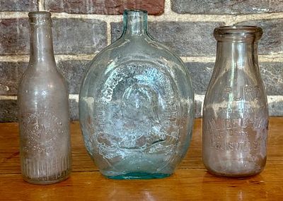 A Trio of Vintage Glass Bottles Including a Washington and Taylor Historical Flask 6"X8". This 