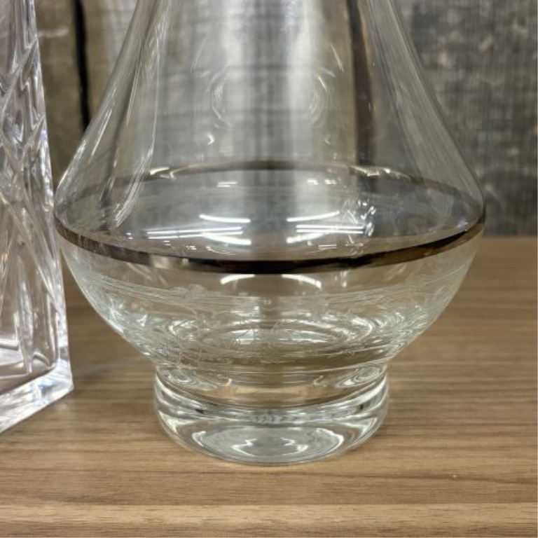 Two Glass Decanters Including a Square Cut Crystal Spirit Decanter and a Flared Decanter with Metallic Trim