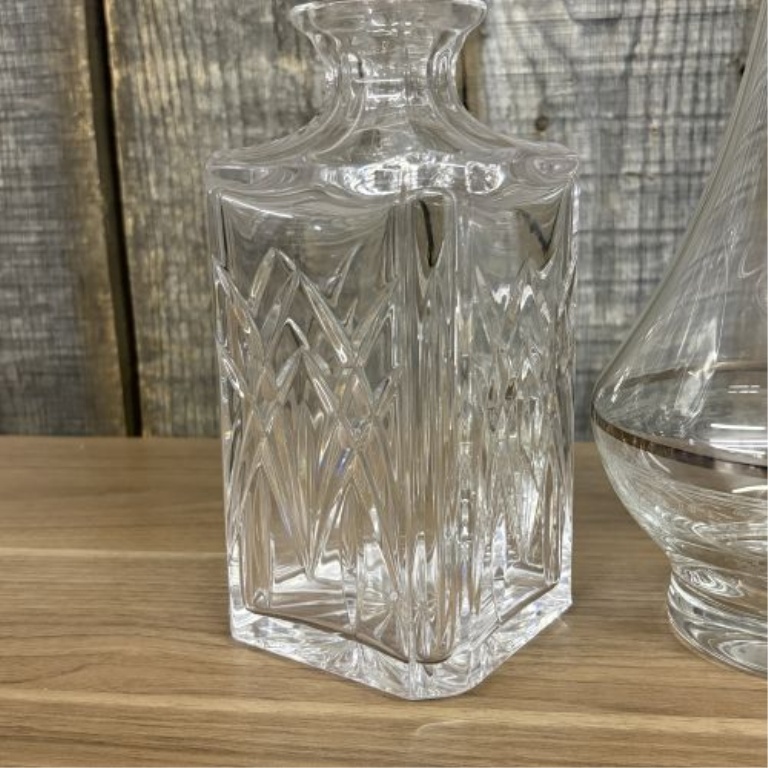 Two Glass Decanters Including a Square Cut Crystal Spirit Decanter and a Flared Decanter with Metallic Trim
