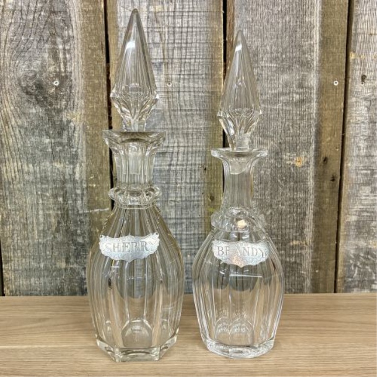 A Pair of Cut Glass Liquor Decanters with Metal Labels and Spire Stoppers