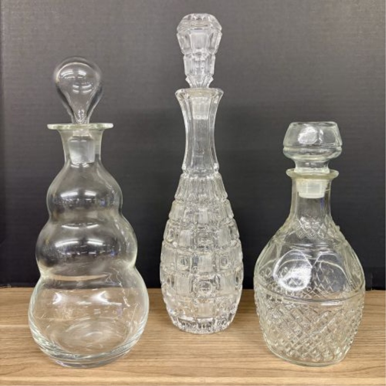A Trio of Assorted Vintage Clear Glass Decanters