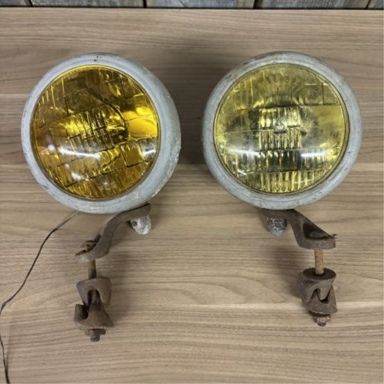 A Pair of Vintage Automotive Fog Lights with Bumper Mount Brackets