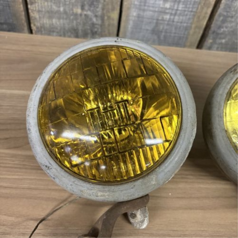 A Pair of Vintage Automotive Fog Lights with Bumper Mount Brackets