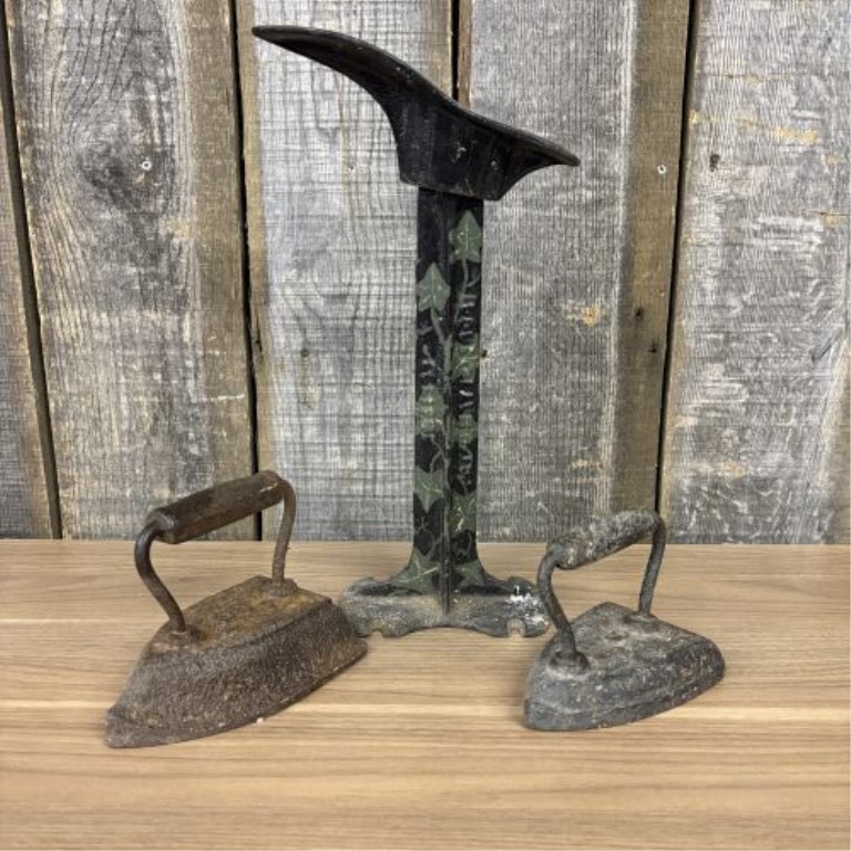A Trio of Antique Cast Iron Items Including a Decorative Cobbler's Last Stand and Two Small Sad Irons