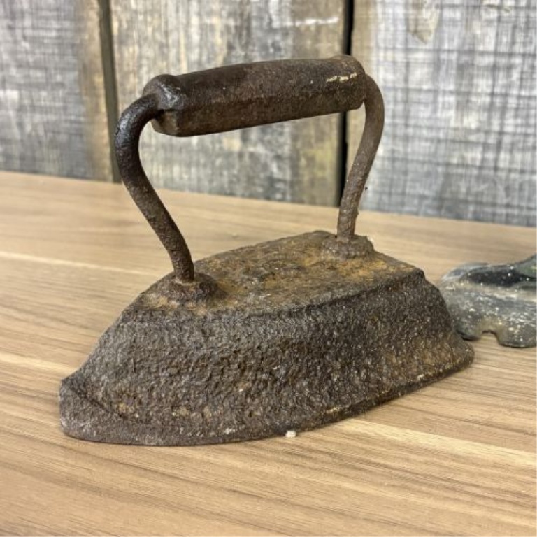 A Trio of Antique Cast Iron Items Including a Decorative Cobbler's Last Stand and Two Small Sad Irons