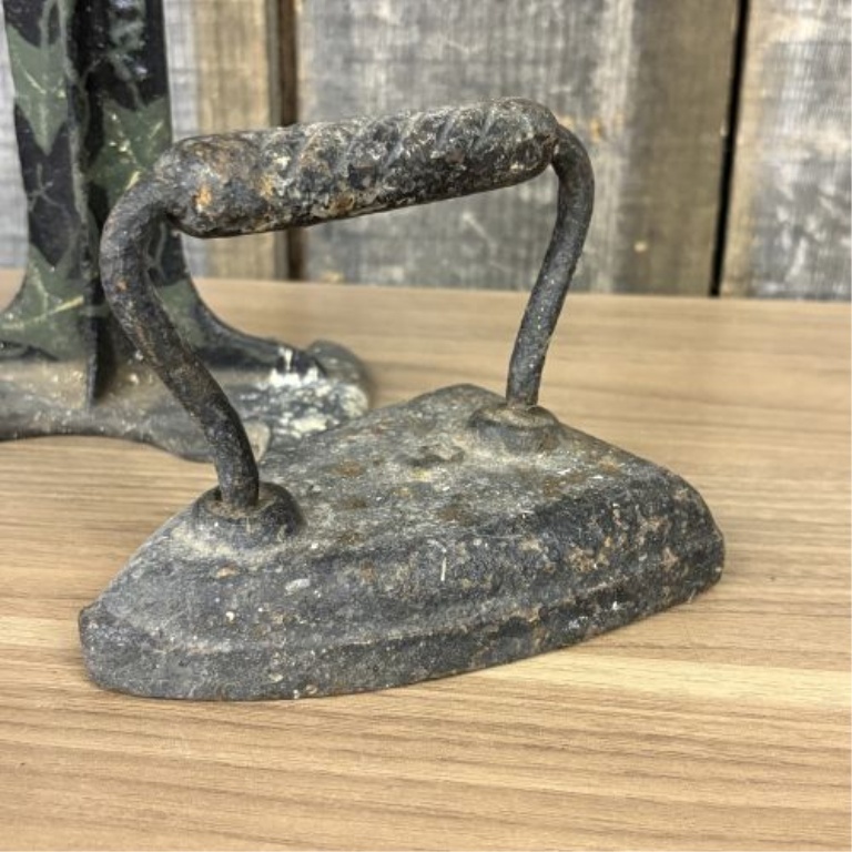 A Trio of Antique Cast Iron Items Including a Decorative Cobbler's Last Stand and Two Small Sad Irons