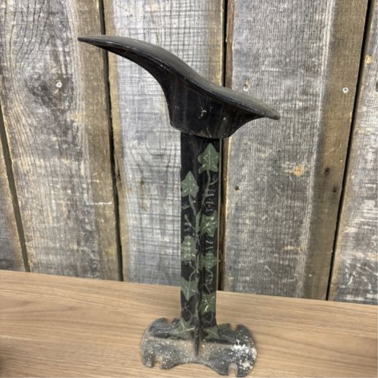 A Trio of Antique Cast Iron Items Including a Decorative Cobbler's Last Stand and Two Small Sad Irons