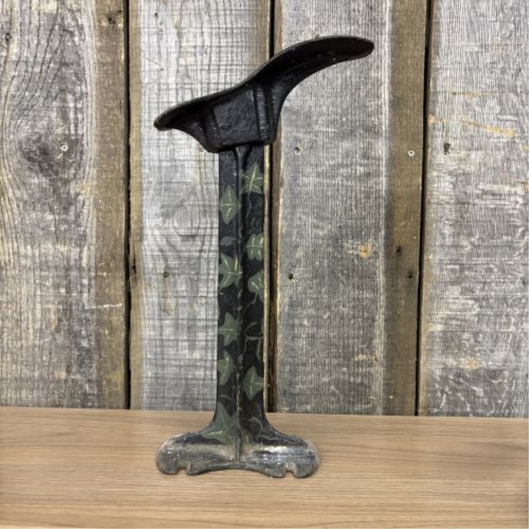 A Trio of Antique Cast Iron Items Including a Decorative Cobbler's Last Stand and Two Small Sad Irons