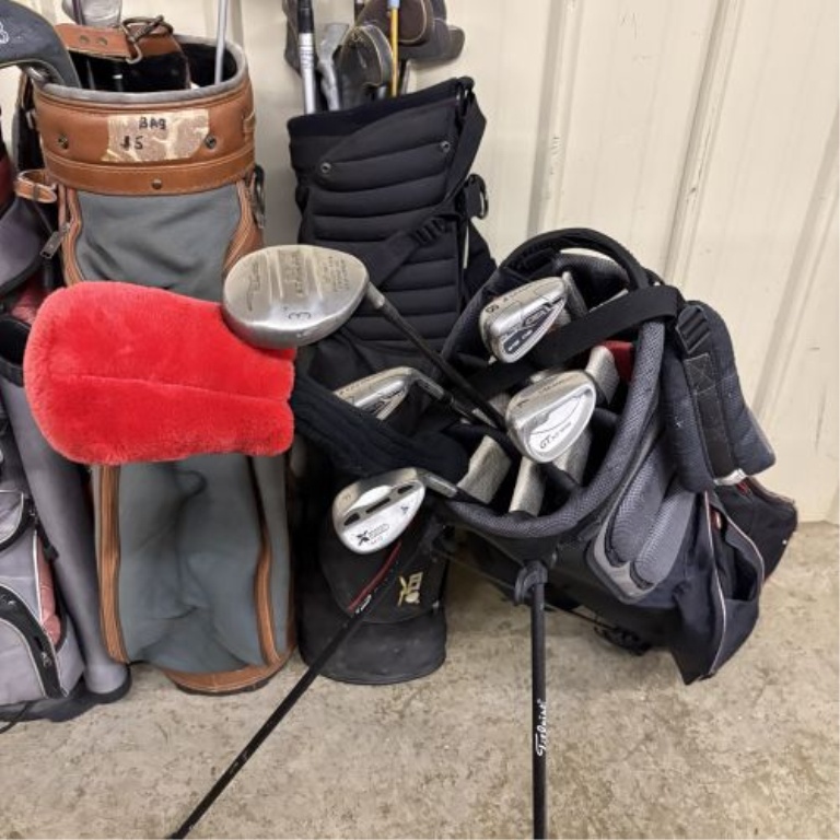 An Assortment of Golf Bags and Mixed Clubs Including Titleist and Adams Golf