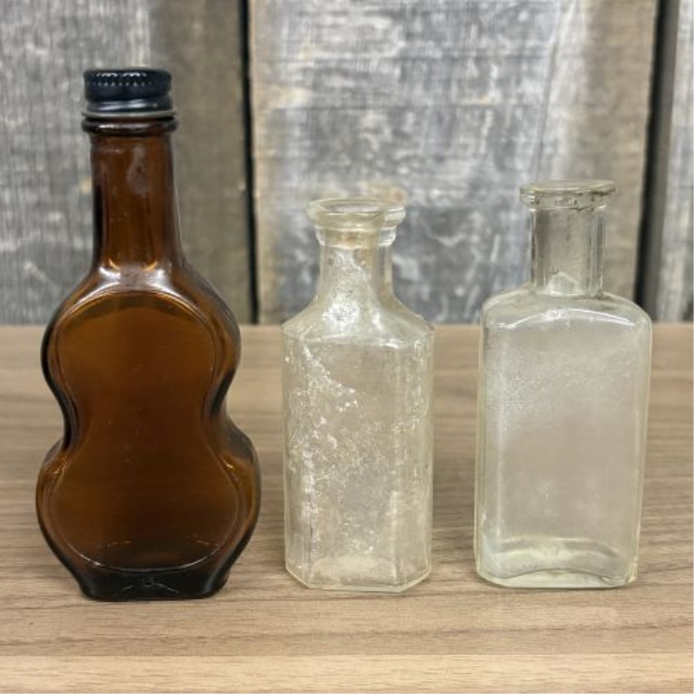 A Collection of Assorted Vintage Clear and Amber Glass Bottles