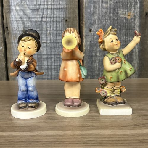 A Trio of Goebel Hummel Porcelain Figurines including Serenade, Little Gabriel, and Spring Cheer
