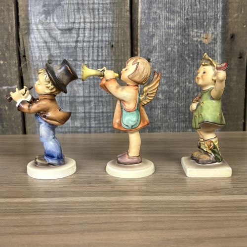 A Trio of Goebel Hummel Porcelain Figurines including Serenade, Little Gabriel, and Spring Cheer