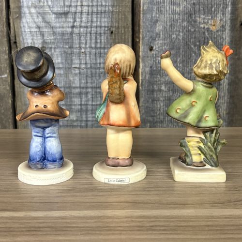 A Trio of Goebel Hummel Porcelain Figurines including Serenade, Little Gabriel, and Spring Cheer