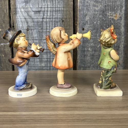 A Trio of Goebel Hummel Porcelain Figurines including Serenade, Little Gabriel, and Spring Cheer