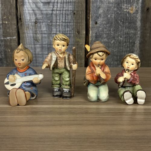 A Set of Four Goebel M.I. Hummel Hand-Painted Ceramic Musical and Wandering Child Figurines