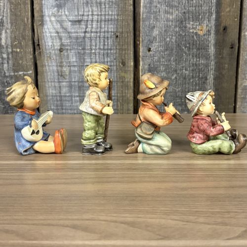 A Set of Four Goebel M.I. Hummel Hand-Painted Ceramic Musical and Wandering Child Figurines