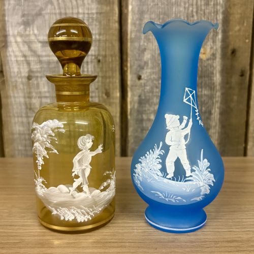Two Mary Gregory Glass Items Including an Amber Decanter and a Frosted Blue Vase