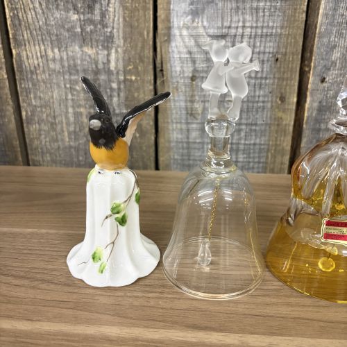 An Assortment of Seven Decorative Porcelain, Glass, and Enameled Metal Bells
