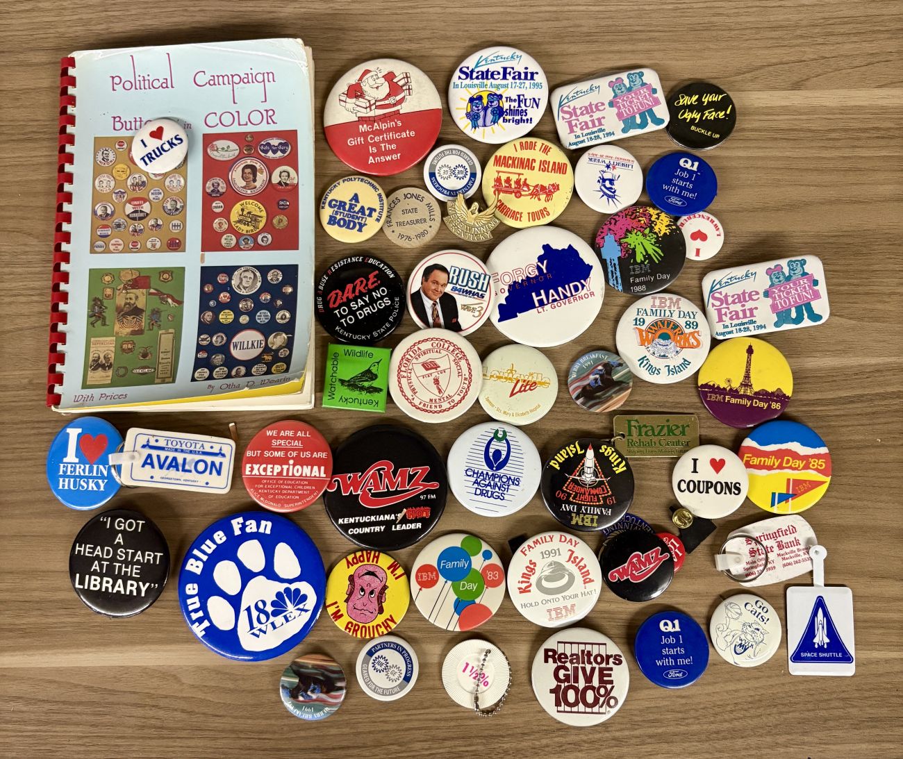 An Assortment of Vintage Pinback Buttons, Keychains, and Political Button Reference Book