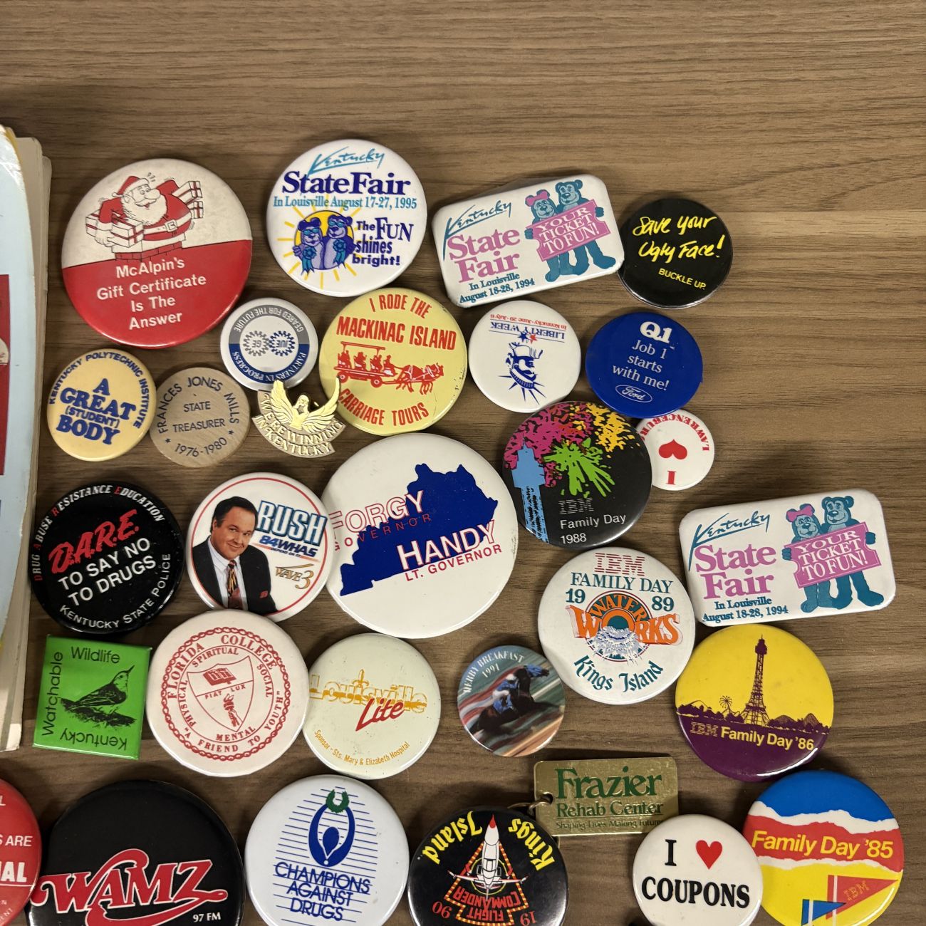 An Assortment of Vintage Pinback Buttons, Keychains, and Political Button Reference Book