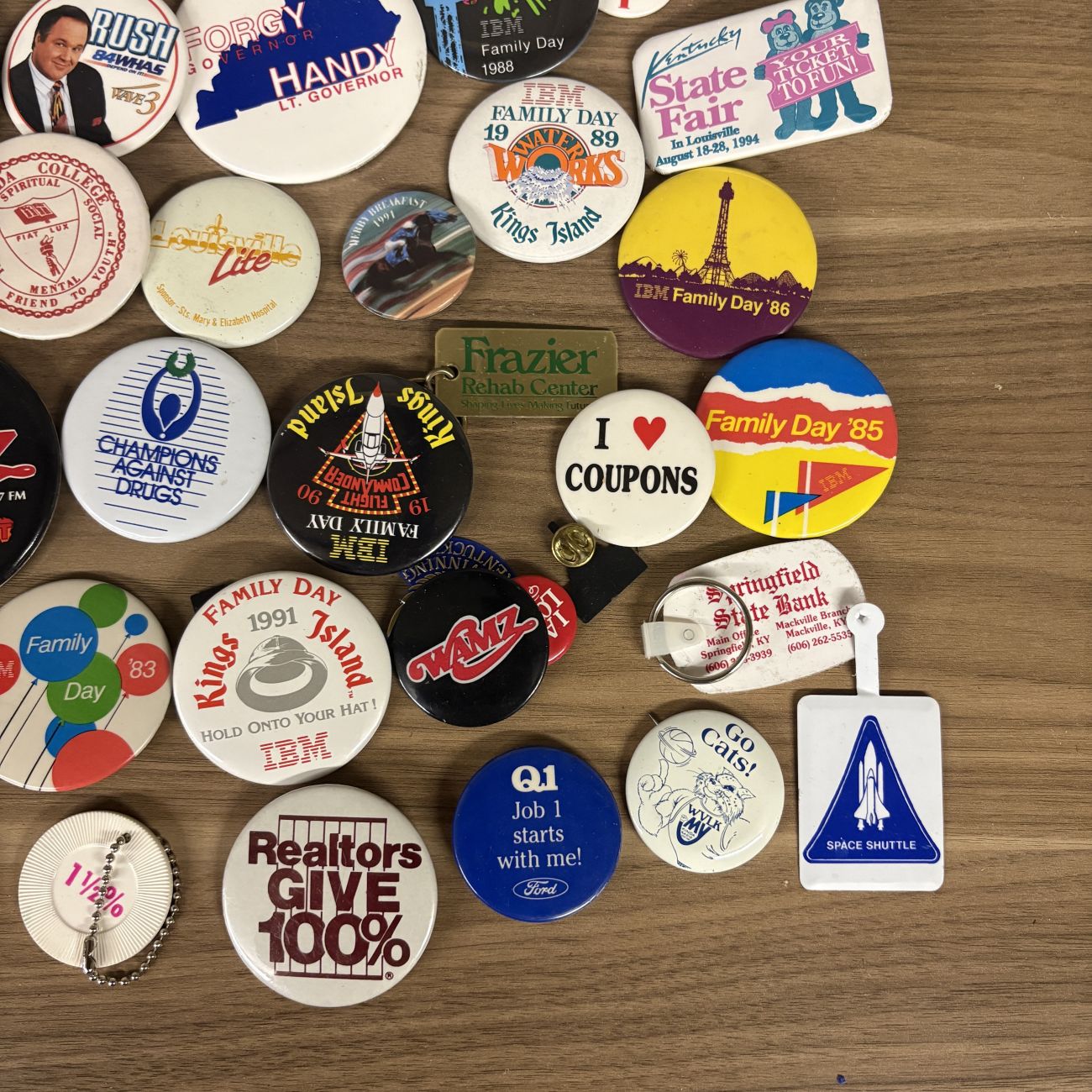 An Assortment of Vintage Pinback Buttons, Keychains, and Political Button Reference Book