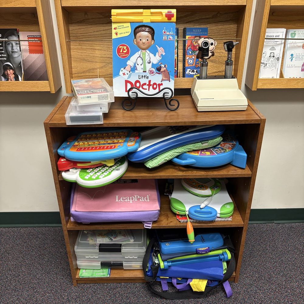 Lot 423: A Collection of LeapFrog Educational Toys, a Welch Allyn Pediatric Diagnostic Center, and a Three-Shelf Bookcase