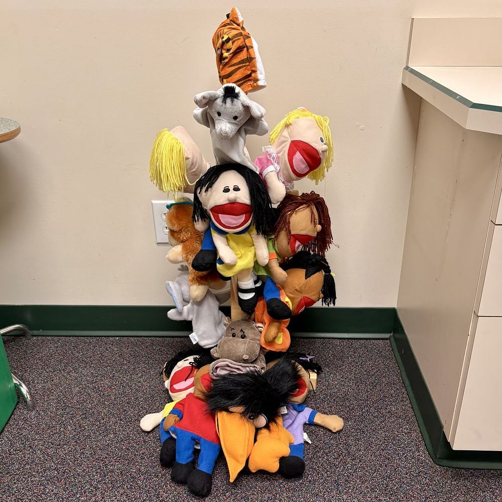 Lot 432: A Collection of Plush Hand Puppets and a Tiered Wooden Display Stand