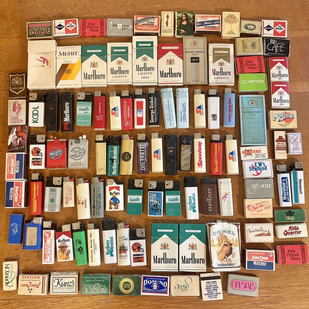 Lot 254: Large Collection of Vintage Tobacco Ephemera Including Cigarette Packs, Lighters, and Matchboxes