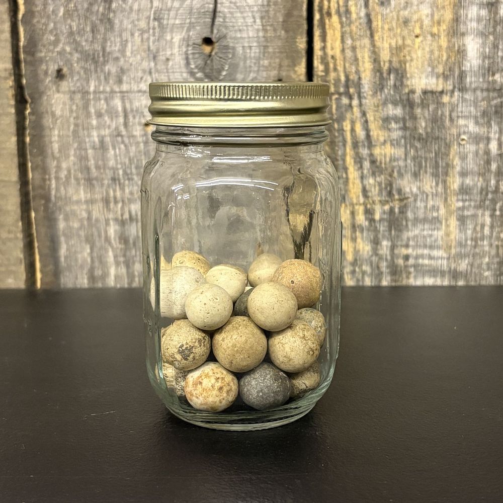 Lot 308: A Collection of Antique Clay Marbles in a Graduated Glass Jar