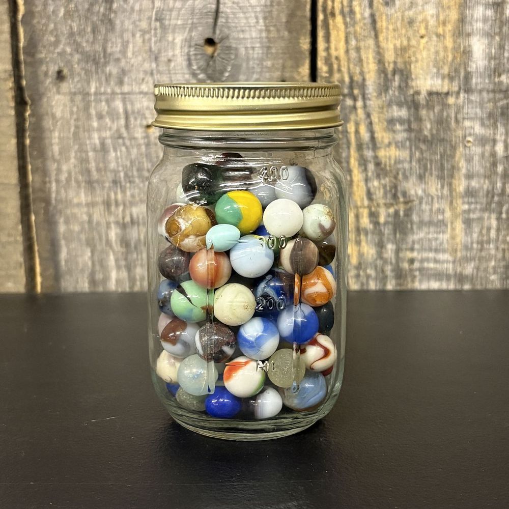 Lot 310: A Collection of Vintage Glass Marbles in a Graduated Glass Storage Jar