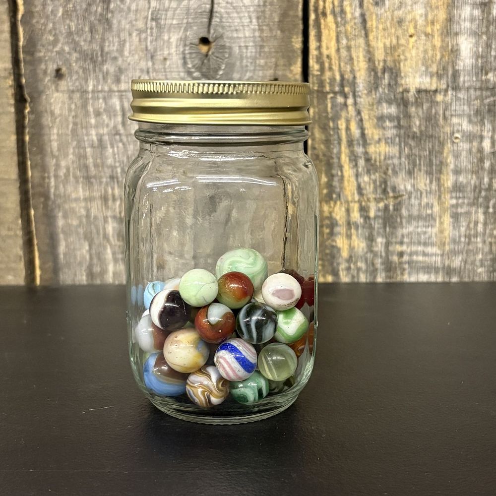 Lot 312: A Collection of Vintage Glass Marbles in a Graduated Glass Jar