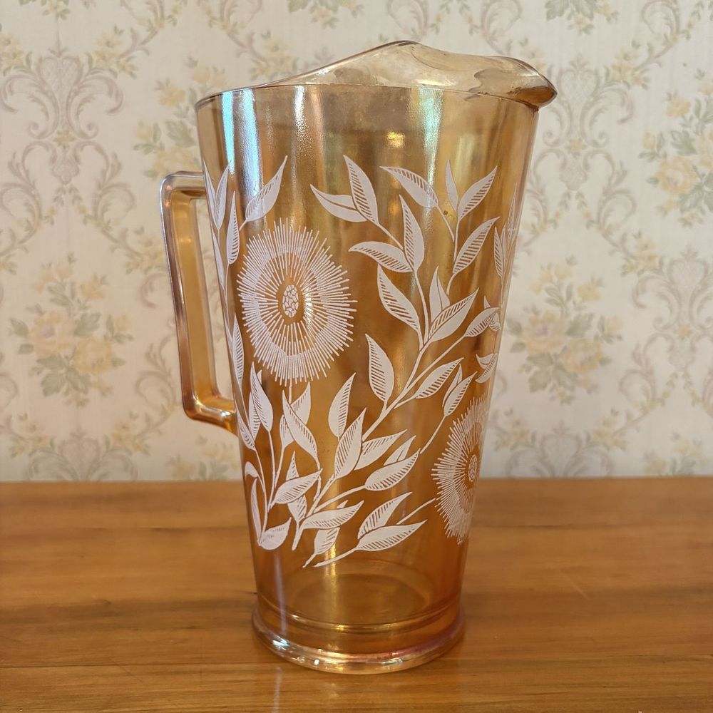 Lot 447: Mid-Century Marigold Carnival Glass Water Pitcher with White Floral Decoration and Ice Lip