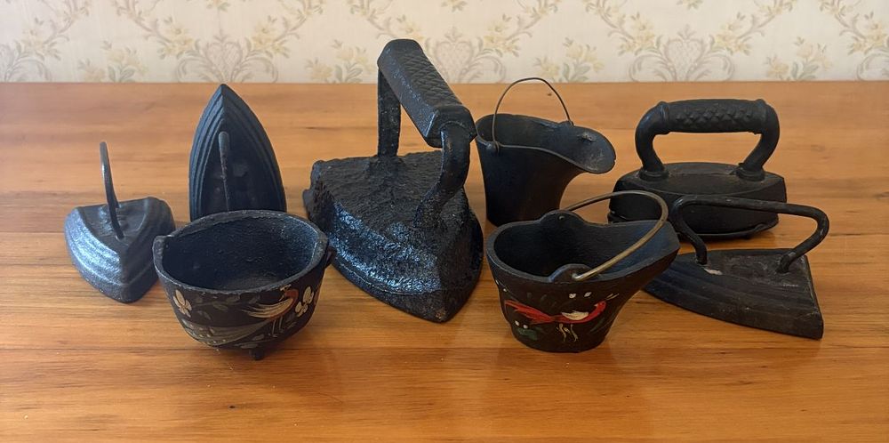 Lot 469: A Collection of Seven Cast Iron Sad Irons and Miniature Painted Coal Scuttles