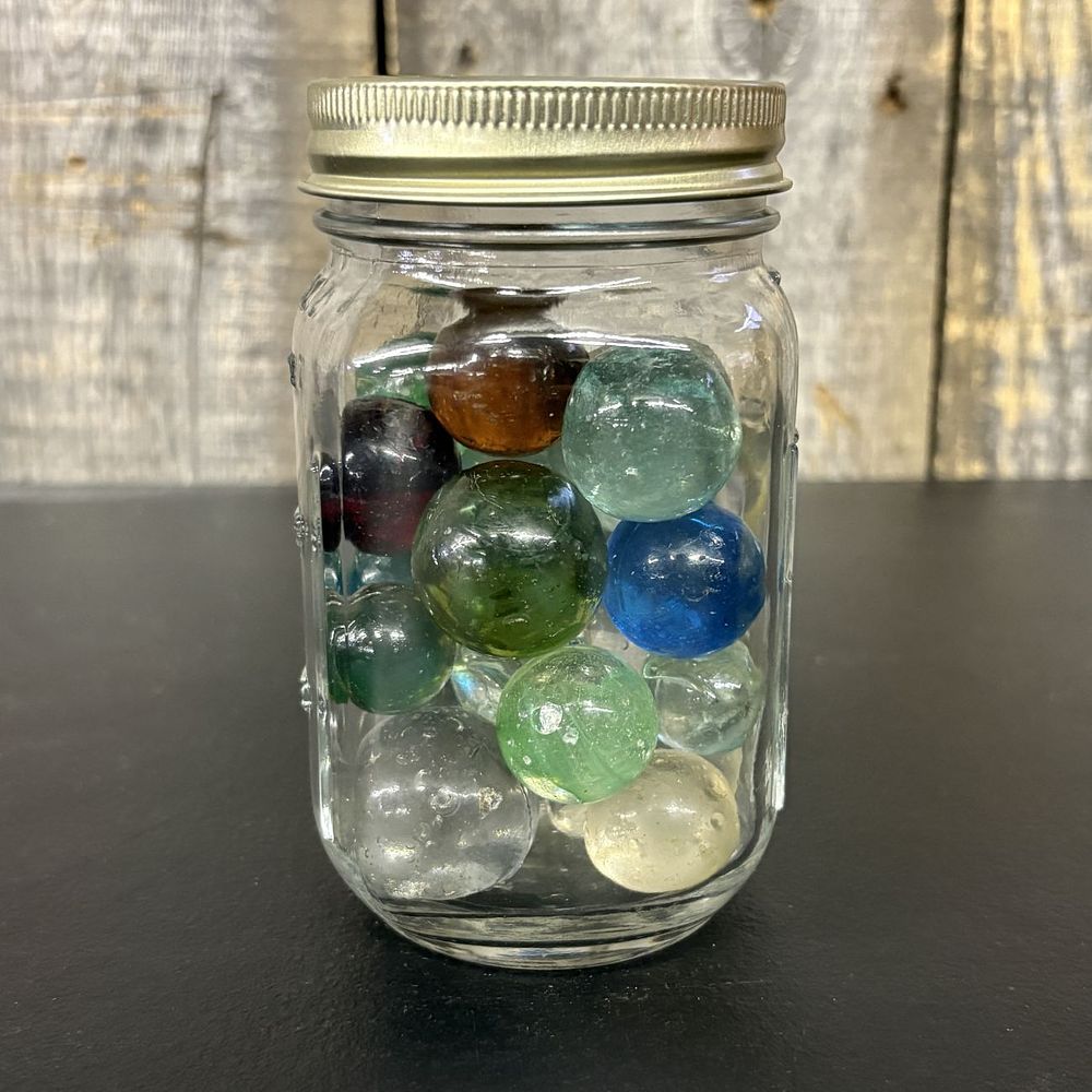 Lot 655: A Collection of Vintage Glass Marbles in a Graduated Glass Jar