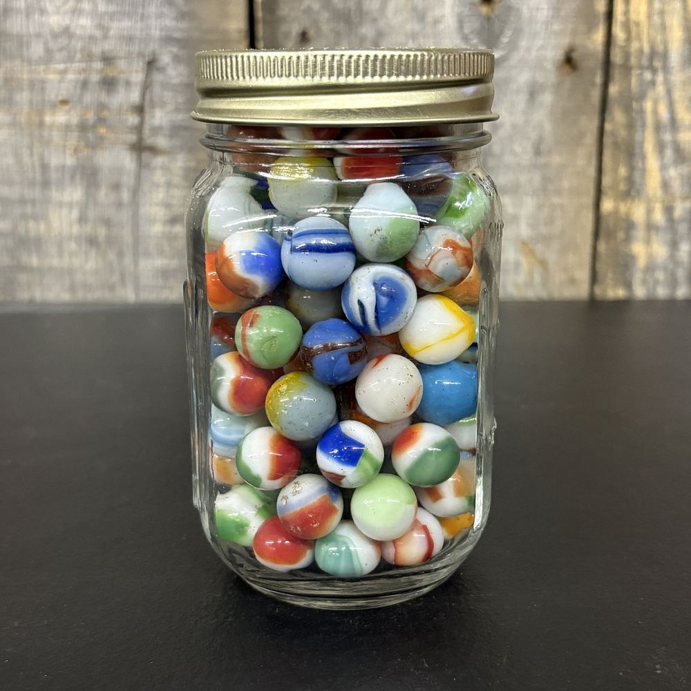 Lot 656: A Collection of Vintage Glass Marbles in a Graduated Glass Jar