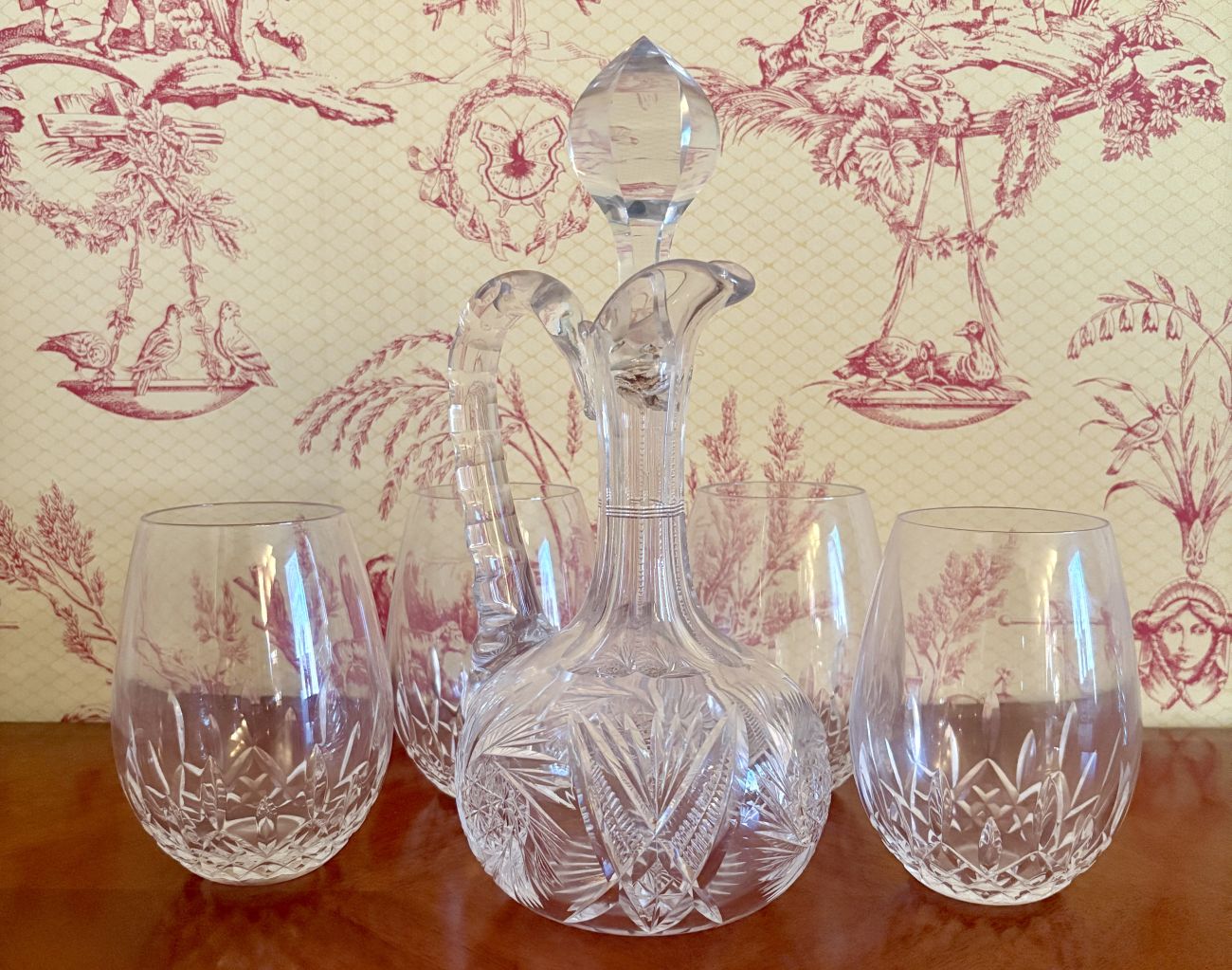 A Set of Cut Crystal Stemless Tumblers and a Handled Claret Jug