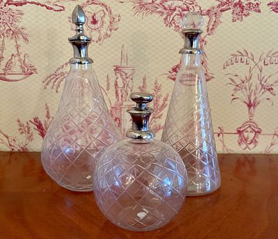 Three Cut Lead Crystal Decanters with Metal and Glass Stoppers. A set of three colorless lead 