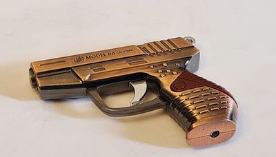 מצית בצורת אקדח, עם סמן קרן לייזר אדום, הגוף עשוי מתכת בגוון ברונזה, הידיות. מצית בצורת אקדח 