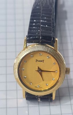 Piaget שעון יד פיאג'ה (רפליקה, לא מקורי), עם רצועת עור בגוון שחור, מסגרת פלדה מוזהבת עגולה. Pia 