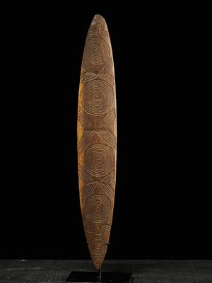 Aboriginal churinga decorated with circles and wavy lines, Australia, 20th century. Carved wood. 