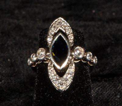 18k white gold shuttlecock ring decorated with a central sapphire and brilliant-cut diamonds. Wei 