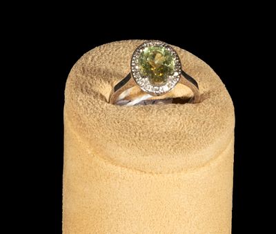 18k white gold ring with oval-cut peridot surrounded by brilliant-cut diamonds. Weight: 4.27 g | 