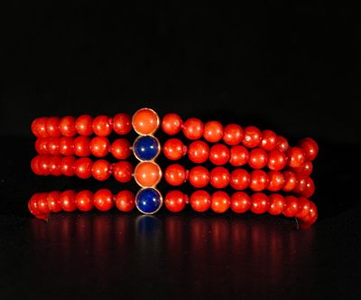 Four-strand coral bracelet with yellow 18k gold clasp and lapis lazuli and coral cabochon. A 