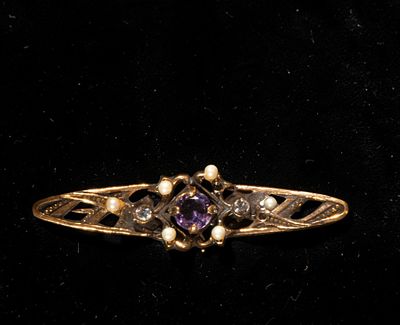 Gold-plated silver brooch with cubic zirconia and amethyst. Its elongated shape and stylized 
