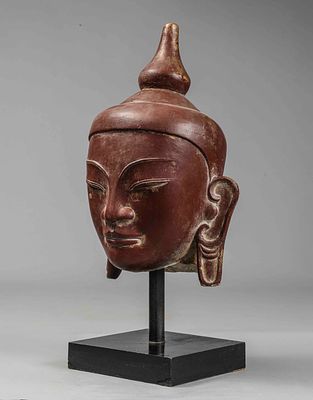 Buddha head, Burmese School of Pagan, 16th century. Beige sandstone lacquered in reddish-ochre 